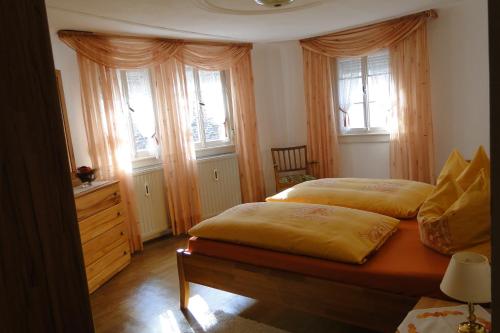 two beds in a bedroom with two windows at Altes Spitzhaus an der Goldroul in Senheim