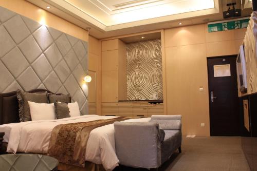 a bedroom with a bed and a chair and a window at Amain Boutique Motel - Tucheng 217 in Tucheng