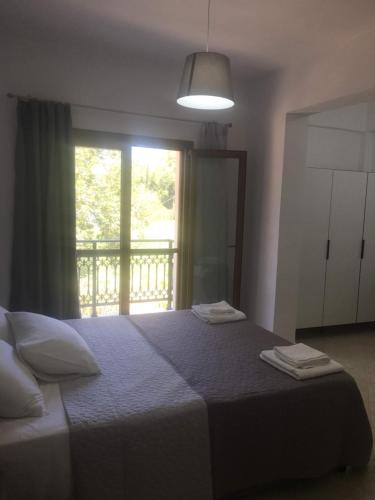 1 dormitorio con 1 cama con 2 toallas en Alekos rooms and apartments, en Samos