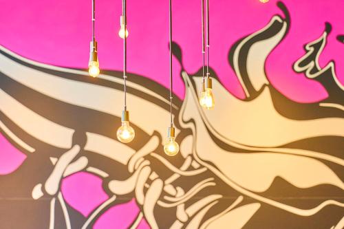 a group of lights hanging from a pink wall at Tokyo Bay Shiomi Prince Hotel in Tokyo