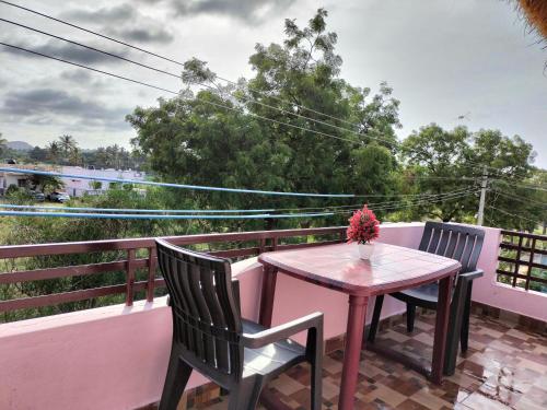 a table and two chairs on a balcony at Prajwal home stay in Hampi