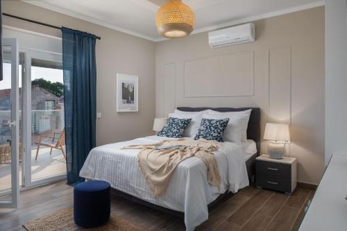 a bedroom with a bed and a balcony at Villas Pakoštane in Pakoštane