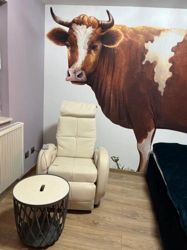 a room with a cow painting on the wall at Siedlisko Kępina Zdrój in Ostrów