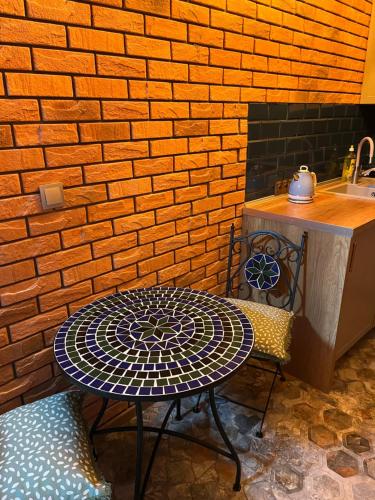 a table and chair in front of a brick wall at Siedlisko Kępina Zdrój in Ostrów