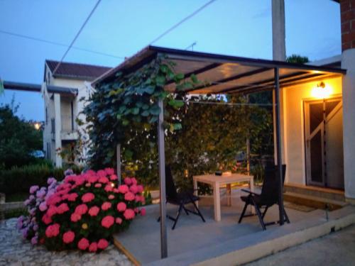 a patio with a table and chairs and flowers at Guest House Marković 279 in Rovinjsko Selo