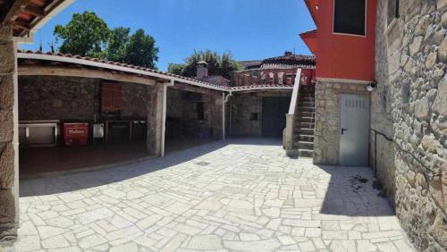 an empty courtyard of a building with a stone wall at Alojamiento Pena da Osa in Sober