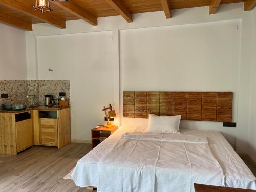 a bedroom with a large bed with a wooden headboard at Green Stone Boutique Hotel in Yeghegnadzor