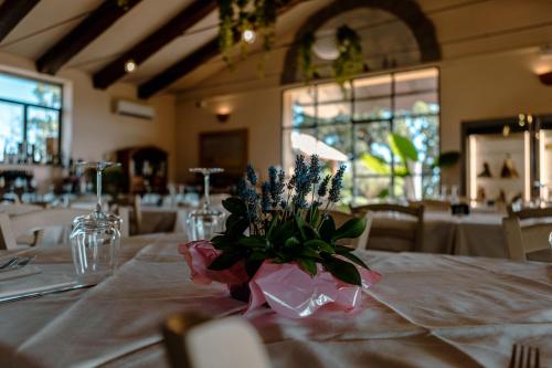 un tavolo con una tovaglia bianca e fiori di Agriturismo Cerrosughero a Canino