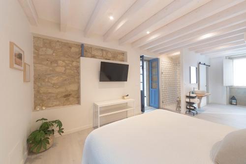 a bedroom with a bed and a tv on the wall at Luz de Viro in Outes