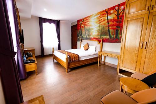 a bedroom with a bed and a painting on the wall at Hoa Viên Hotel - Suối khoáng Kim Bôi in Hòa Bình