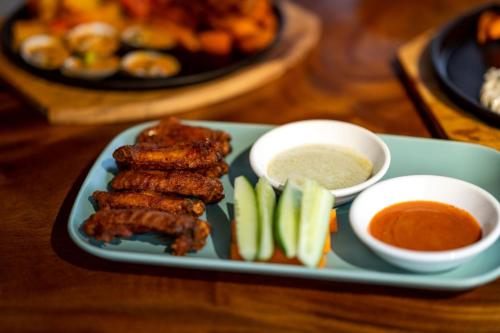 a plate of food with meat and vegetables and dipping sauce at BeachWalk Koh Rong in Koh Rong Island