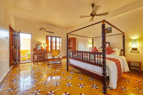 a bedroom with a canopy bed and a wooden floor at VILLA DU OCEAN in Puducherry