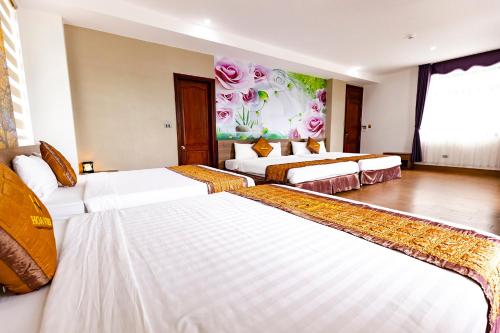 a hotel room with three beds in a room at Hoa Viên Hotel - Suối khoáng Kim Bôi in Hòa Bình