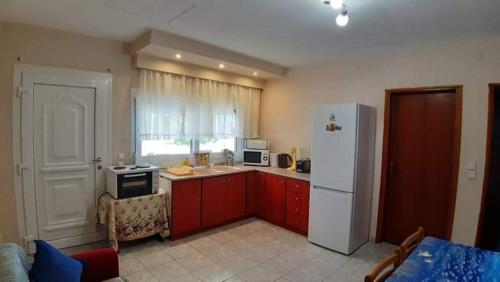 奧林匹亞達的住宿－Aristoteles Apartments，厨房配有红色橱柜和白色冰箱