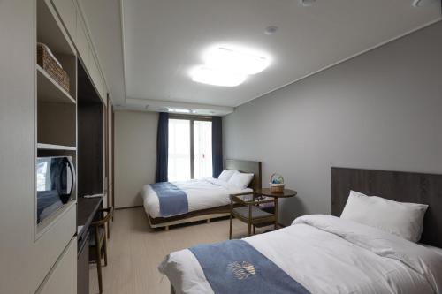 Habitación de hotel con 2 camas y TV en Golden Planet Hotel en Icheon