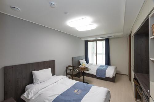 Habitación de hotel con 2 camas y ventana en Golden Planet Hotel en Icheon
