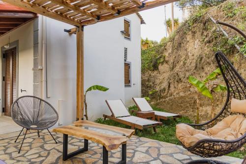an outdoor patio with chairs and a swing at Villa Philippos in Vitalades