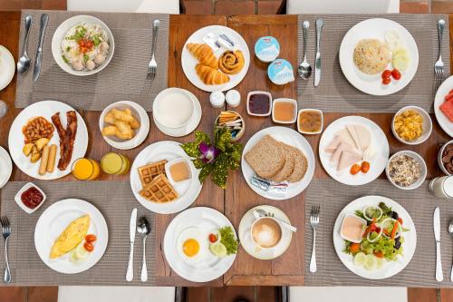 a table with plates of food on it at The Legend Chiang Rai Boutique River Resort & Spa in Chiang Rai