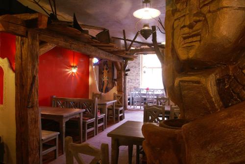 a restaurant with wooden tables and chairs and a red wall at Penzion Hacienda Ranchero in Pardubice