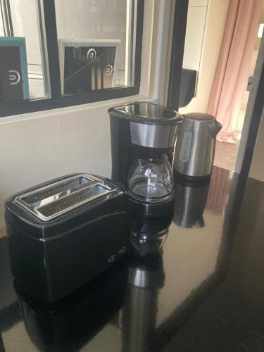 a coffee maker sitting on a counter with two trash cans at L'INTEMPOREL - A 300m de la gare de Tours in Tours