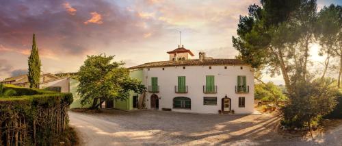 a large white building with a tower on top of it at Masia Can Comas in Sant Pere de Ruidebitlles
