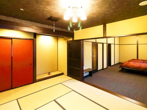 a room with a bed and a room with stalls at Ryokan Karasawa in Kanazawa