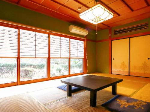 a room with a table in a room with windows at Ryokan Karasawa in Kanazawa