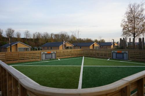 a tennis court in front of a wooden fence at EuroParcs De Kraaijenbergse Plassen in Groot-Linden
