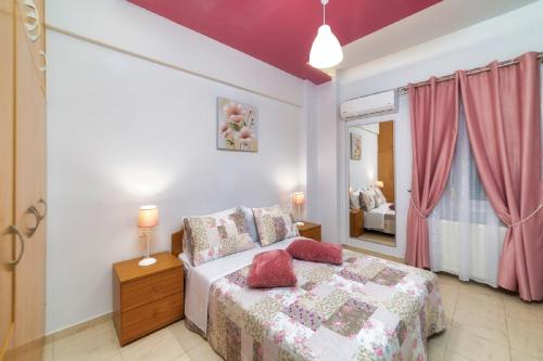 a bedroom with a bed and a window with pink curtains at Blue Boutique Apts in Amoudara Herakliou