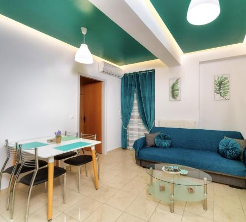 a living room with a blue couch and a table at Blue Boutique Apts in Amoudara Herakliou