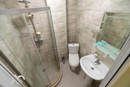a bathroom with a shower and a toilet and a sink at WoodSea in Batumi