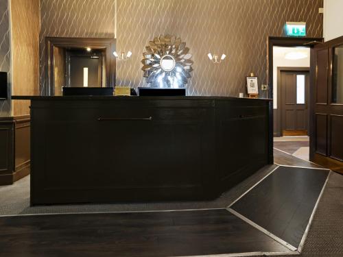 a reception desk in a hotel lobby with a mirror at Dryfesdale Hotel - BW Signature Collection in Lockerbie