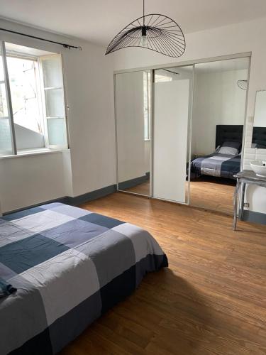Schlafzimmer mit einem Bett und einem Spiegel in der Unterkunft Le 31 
