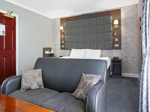 a hotel room with a bed and a chair at Dryfesdale Hotel - BW Signature Collection in Lockerbie