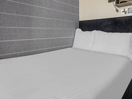 a bed with white sheets and pillows in a room at Dryfesdale Hotel - BW Signature Collection in Lockerbie
