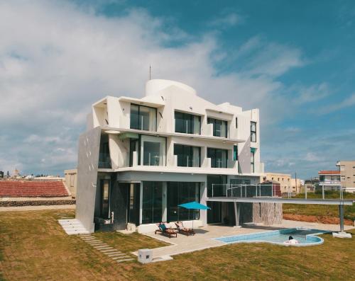 un edificio blanco con una piscina frente a él en BEACH FRONT VILLA, en Baisha