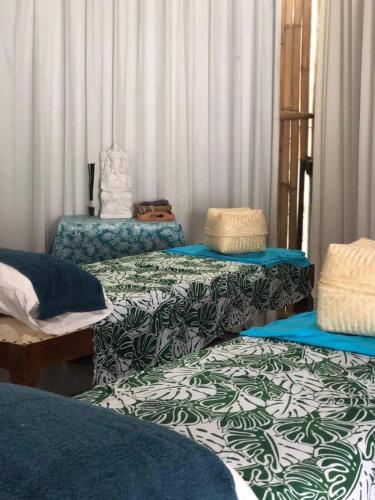 a room with three beds with blue and green sheets at Salt Resort & Spa in Amed