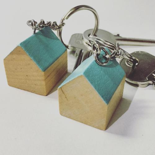 a pair of wooden keychains on a key chain at LA OTRA KASA in Alameda del Valle