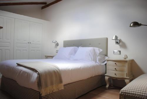 a bedroom with a large bed with white sheets and pillows at LA OTRA KASA in Alameda del Valle