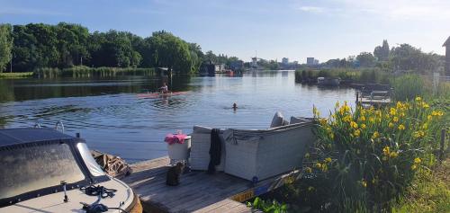 a boat on a dock on a lake with people in the water at Verborgen Parel aan de Rotte in Rotterdam