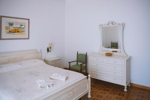 ein Schlafzimmer mit einem Bett, einem Spiegel und einer Kommode in der Unterkunft Il Viaggiatore Errante in Fondi