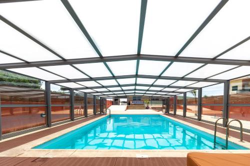 an indoor swimming pool with a glass ceiling at O CANTINHO ENTRE A RIA E O MAR - with hot water pool all year round in Torreira