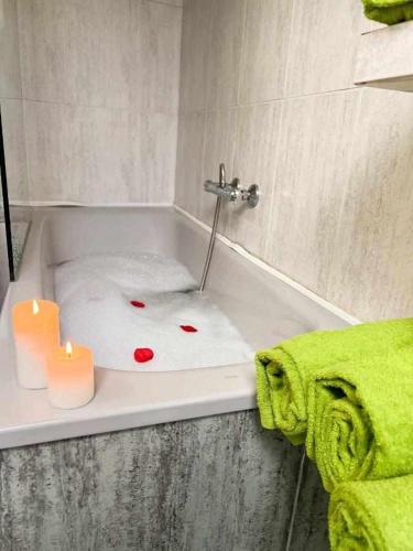 a bathroom with a bath tub with two candles in it at Casa del Puente - MurallaHomes in Ávila