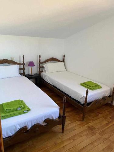 two beds sitting in a room with at Casa del Puente - MurallaHomes in Ávila