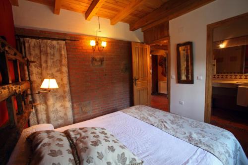 a bedroom with a bed and a brick wall at Casa rural El Leñador in Ávila