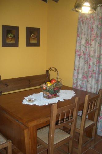 a dining room table with a basket of fruit on it at Casa rural El Leñador in Muñana
