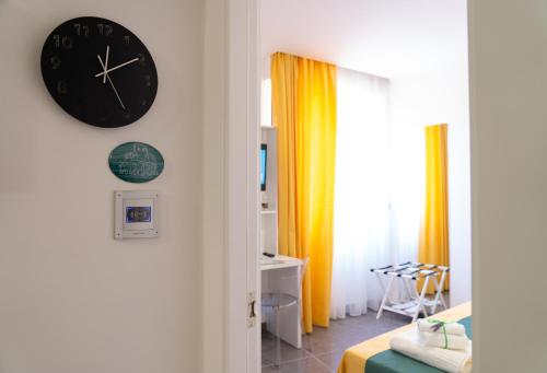 a clock on a wall next to a bedroom at L'Orologio Guest Rooms in Scalea