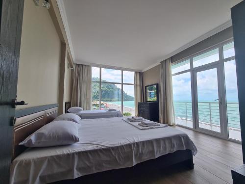 a bedroom with a bed with a view of the ocean at Black Sea Hotel in Kvariati