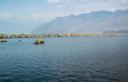 ein kleines Boot in einem großen Wasserkörper in der Unterkunft Shiraz Deluxe Houseboat in Srinagar