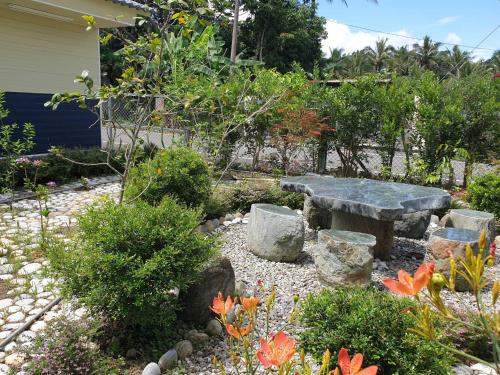 a stone bench sitting in the middle of a garden at 月眉民宿 in Yuemei